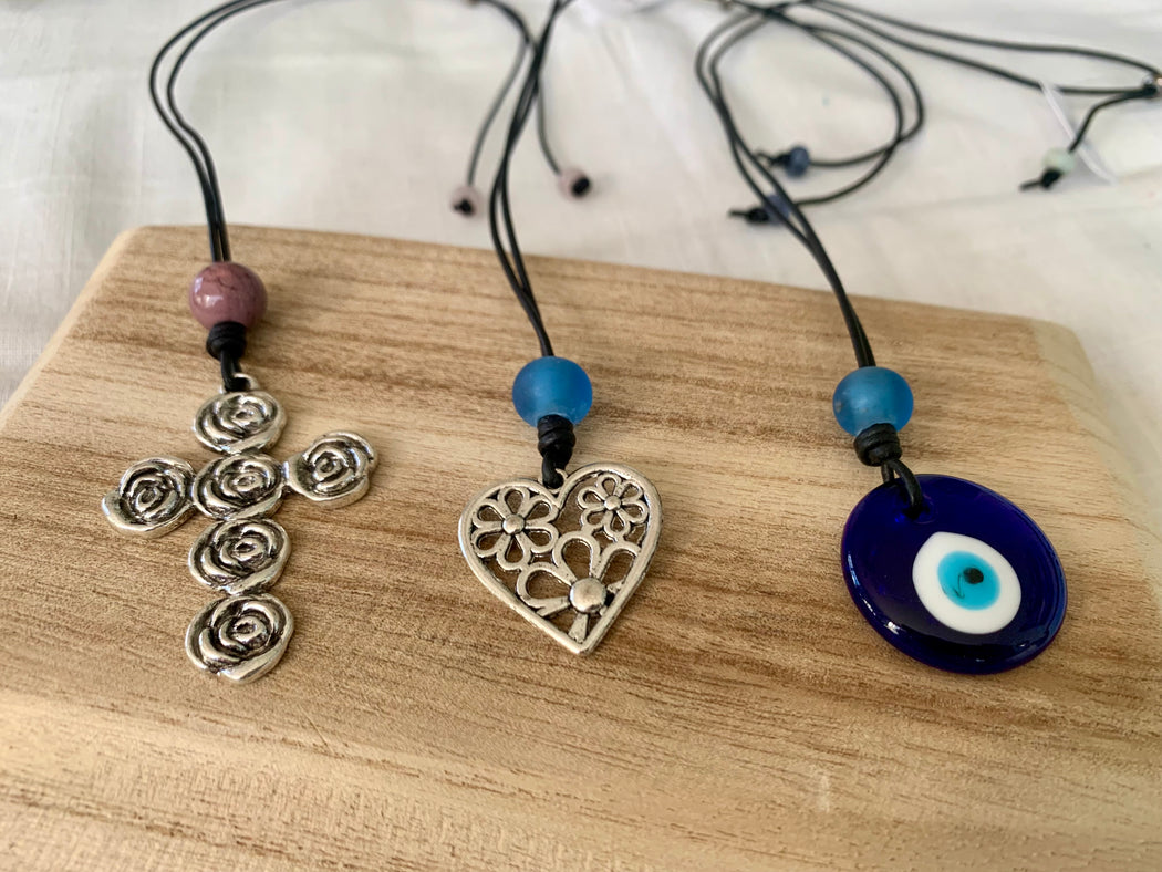 Leather necklace with your choice of a rose cross, heart or glass evil eye pendant on leather.