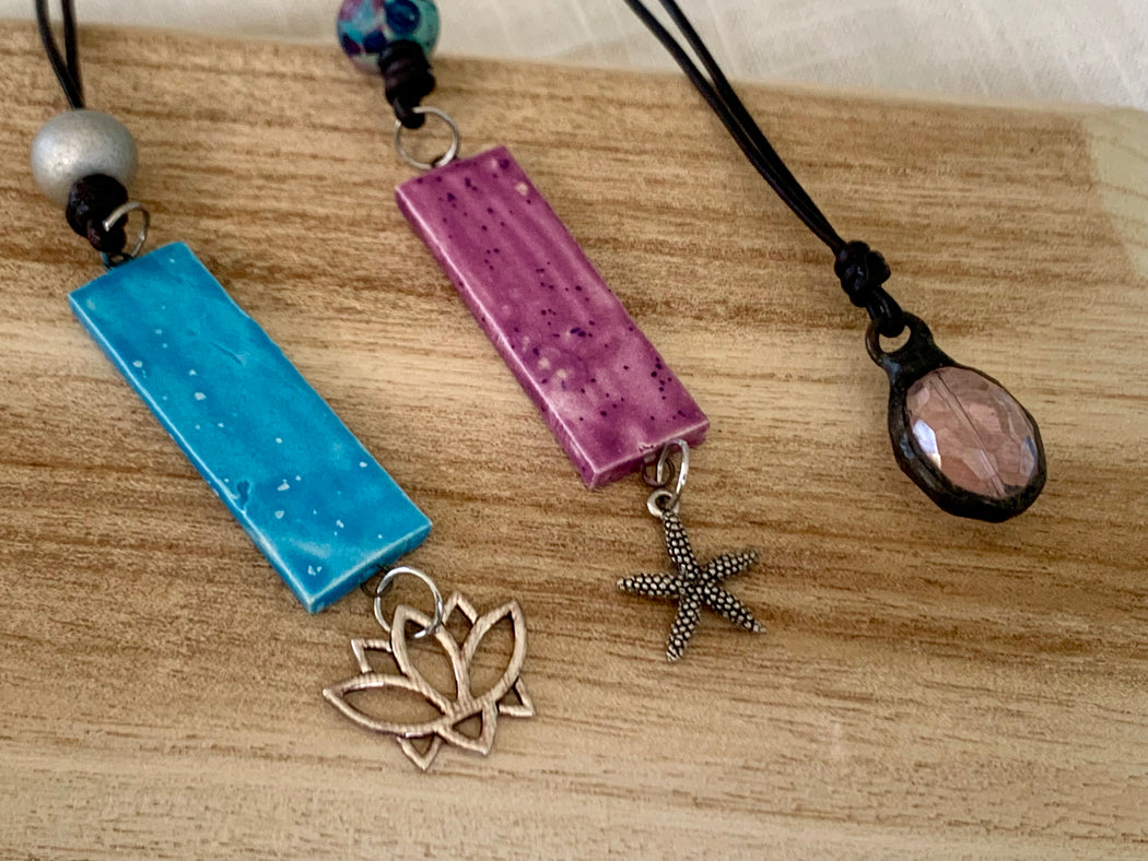 a lotus, starfish or crystal pendant on leather cord.