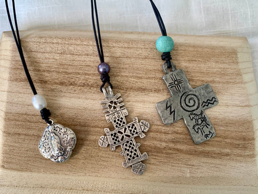 Mother Mary, Coptic cross and a petroglyph cross pendant neckalces on leather.