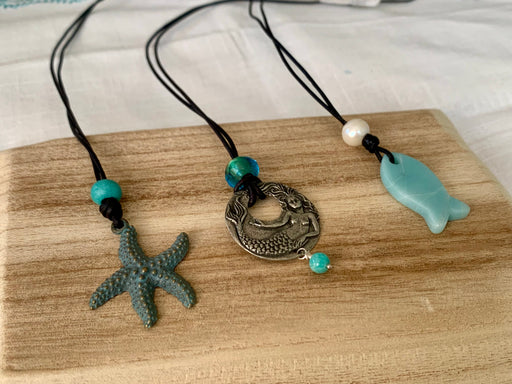 A starfish, Mermaid and Amazonite fish pendant necklaces on leather cord.